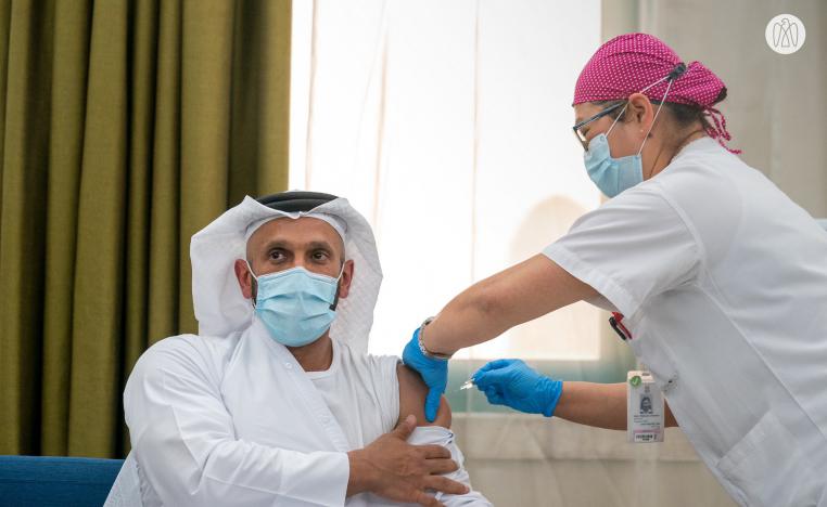 عبد الله بن محمد آل حامد، رئيس دائرة الصحة بأبوظبي، أول متطوع يتلقي اللقاح (الصورة من صفحة مكتب أبوظبي الإعلامي على تويتر)