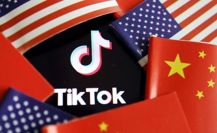 شعار تطبيق تيك توك يظهر وسط علمي الولايات المتحدة والصين