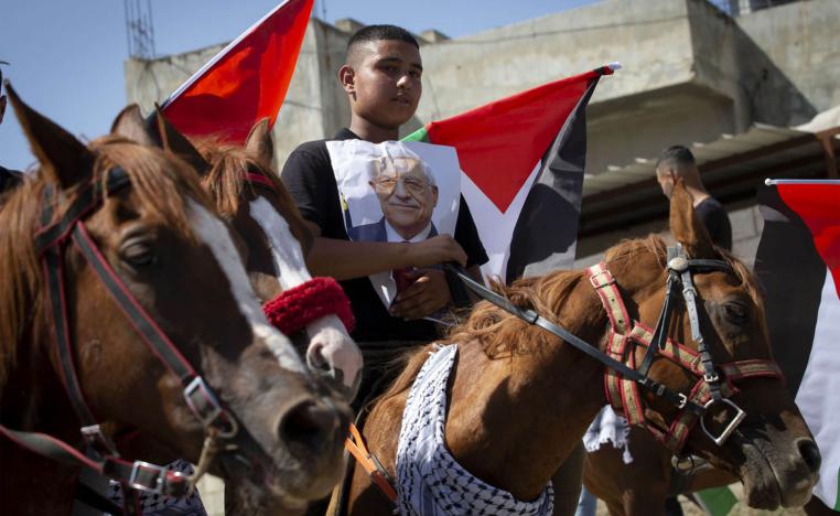 صبي فلسطيني يرفع صورة الرئيس محمود عباس