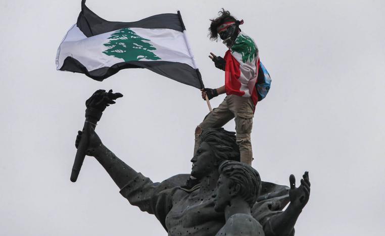 محتج لبناني يعتلي تمثال الشهداء وسط بيروت