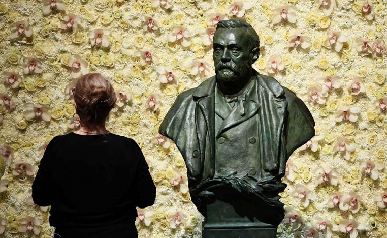 زائرة أمام تمثال نصفي لمؤسس جائزة نوبل ألفريد نوبل