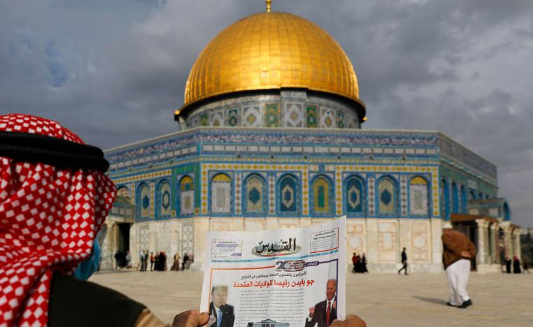 فلسطيني يعرض صحيفة في القدس تنقل خبر فوز بايدن