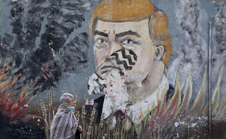فلسطينية تمر بجانب صورة لترامب مرسومة على جدار في غزة