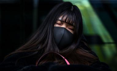 امرأة صينية تنام في محطة قطار
