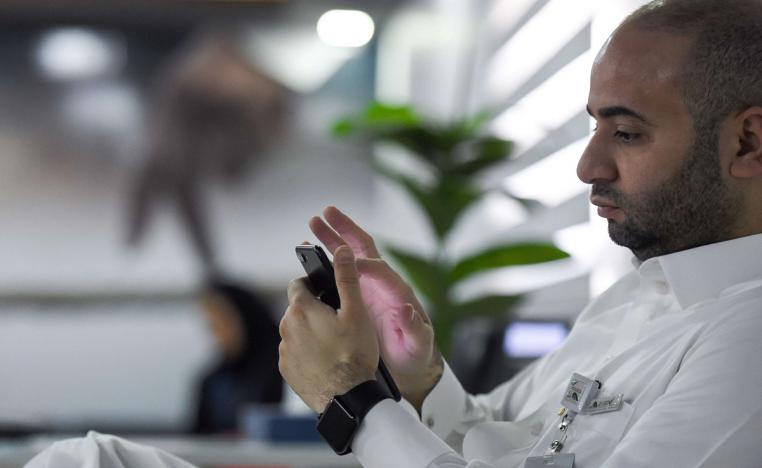 موظف سعودي يتصفح هاتفه في مكتبه بالرياض