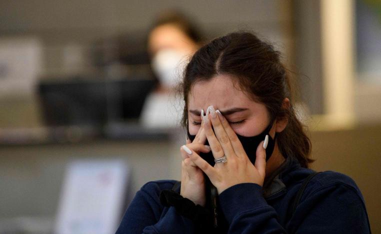 فتاة أميركية تبكي أحد أقاربها المتوفي جراء الاصابة بكورونا