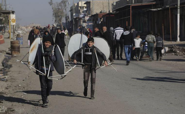 أطفال يحملون صحونا لاقطة في الموصل