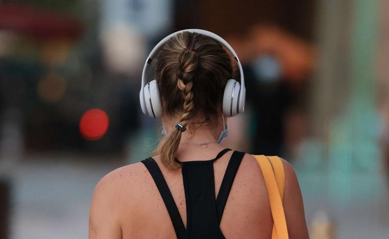 فتاة تستمع للموسيقى عبر سماعة الأذن