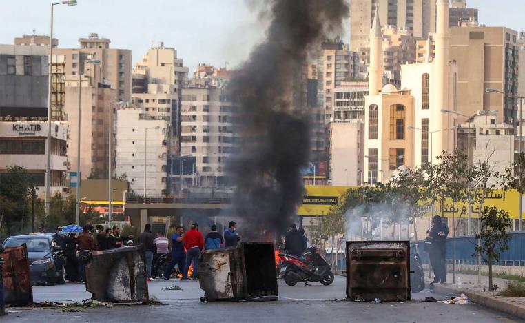 Demonstrators block a road in Beirut with garbage bins