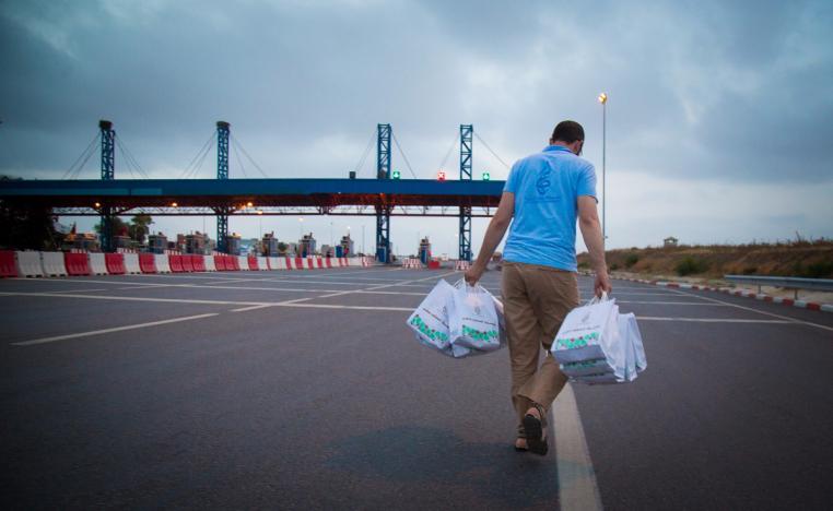 أحد العاملين في مؤسسة عطاء يوزع طرود الخير (الصورة من صفحة المؤسسة على فيسبوك)