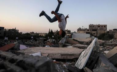 طفل فلسطيني يلعب على اطلال مبان مهدمة بالقصف في غزة