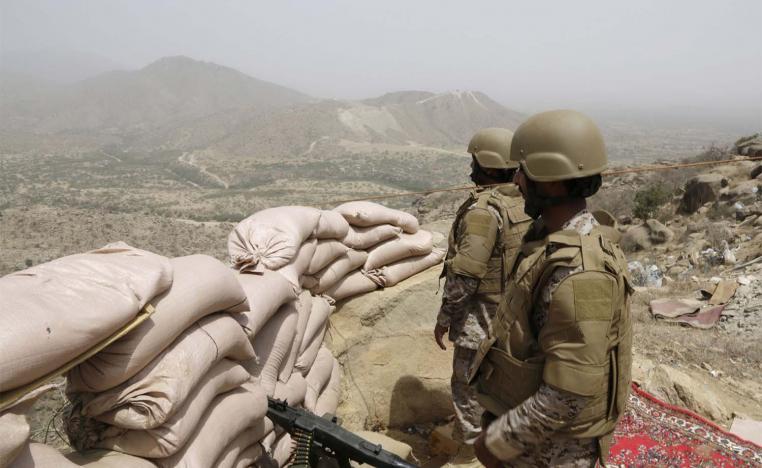 Saudi soldiers stand guard from behind a sandbag barricade at the border with Yemen in Jazan