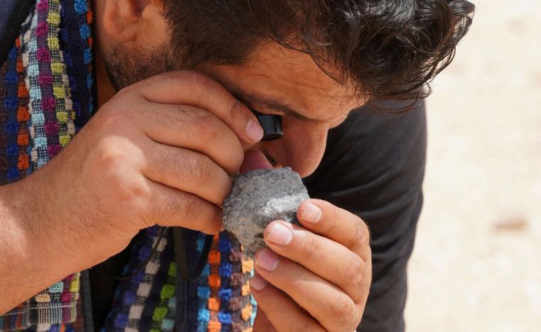 صياد النيازك علي المغاري يتفقد حجرًا بالقرب من قرية تامري في المغرب