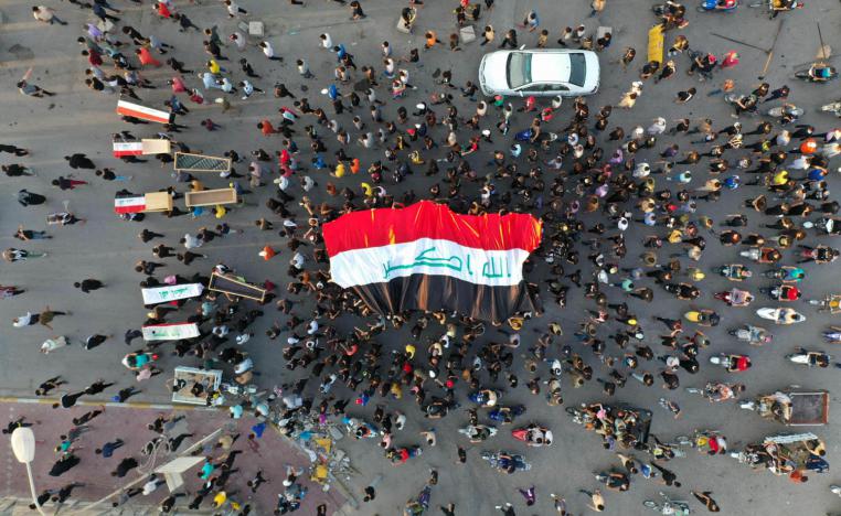 عراقيون يحملون علما عراقيا وتوابيت فارغة يتظاهرون وسط بغداد