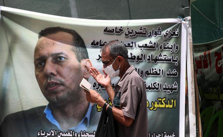 عراقي يمر بجانب ملصق للشهيد هشام الهاشمي في بغداد