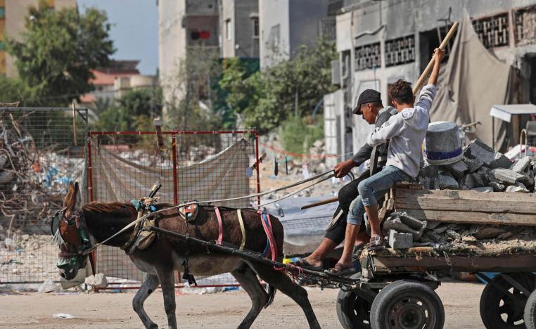 فلسطينيان يقودان عربة في غزة