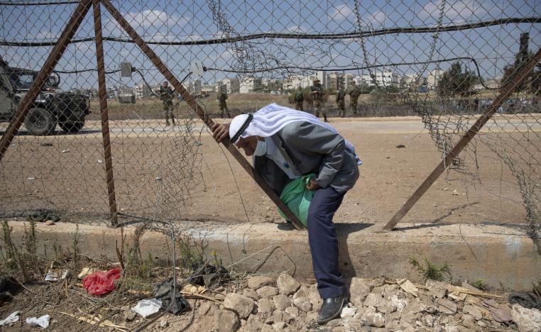 عامل فلسطيني يعبر منطقة الاسلاك الشائكة الفاصلة بين غزة واسرائيل
