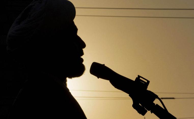 شيخ شيعي يتحدث إلى مجموعة من الحشد الشعبي