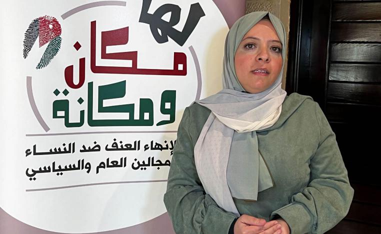 ناشطة أردنية مع ملصق لجمعية المرأة في الأردن