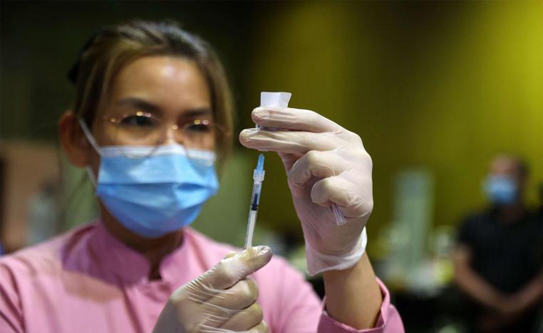 A health worker prepares a dose of the COVID-19 vaccine in Doha