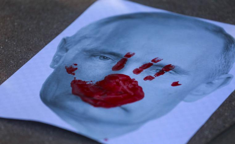 صورة ملوثة ببصمات دامية للرئيس الروسي فلاديمير بوتين