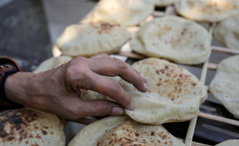 مصرية تشتري خبزا في القاهرة