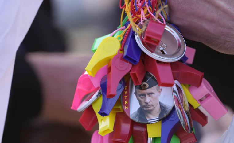 متظاهر صربي يرتدي شارة تحمل صورة الرئيس الروسي فلاديمير بوتين