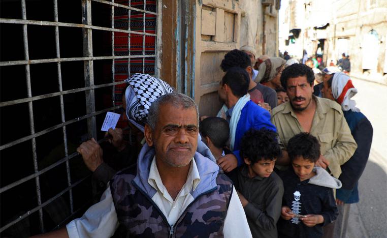 Yemenis wait in line to receive a free fast-breaking "Iftar" meal in Sanaa
