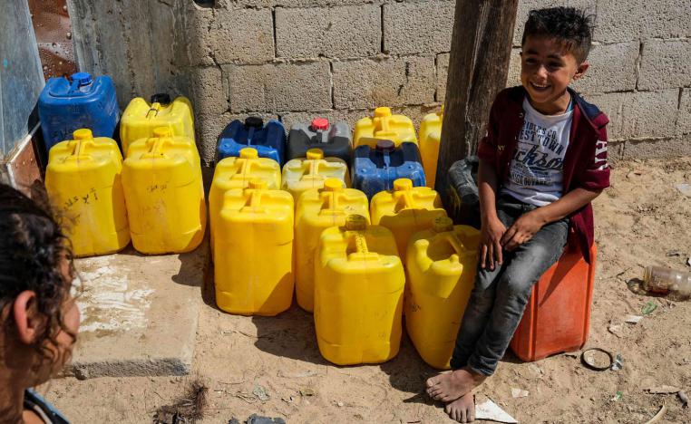 أطفال فلسطينيون ينتظرون توزيع الماء في رفح