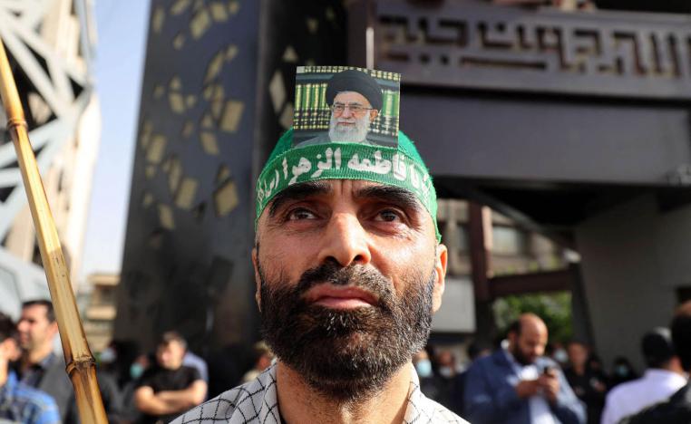 إيراني يضع صورة المرشد الأعلى علي خامنئي على رأسه