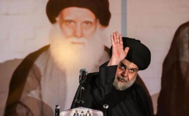 الزعيم الشيعي مقتدى الصدر مع صورة لأبيه محمد صادق الصدر