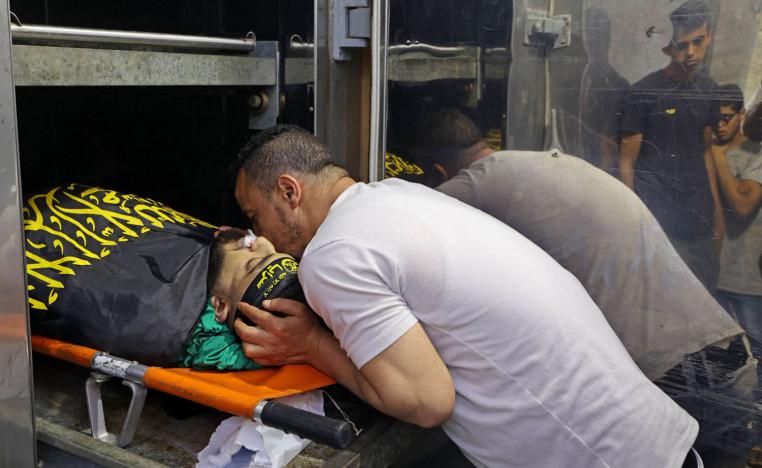 فلسطيني يقبل جثمان ناشط قتل في غارة أمنية إسرائيلية في جنين
