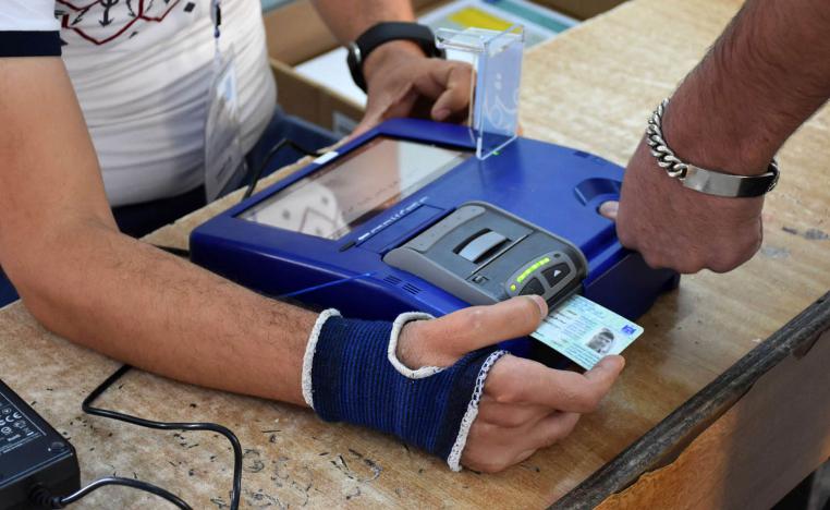 عراقي يصوت في الانتخابات التشريعية باستخدام بطاقة التصويت