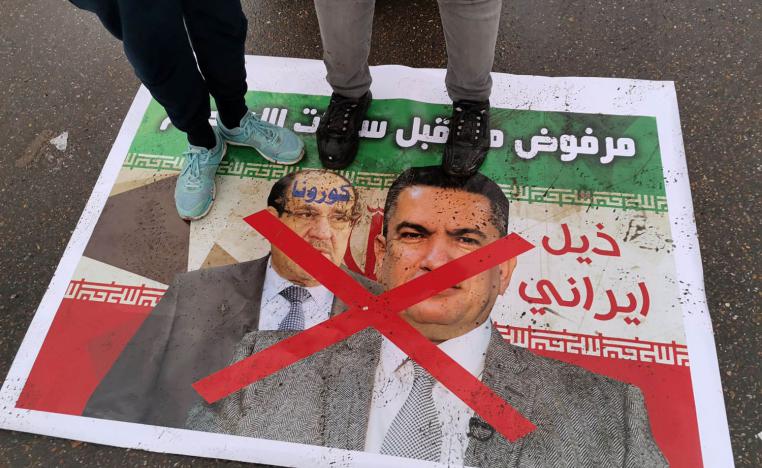 عراقيون يدوسون على صور لرئيس الوزراء العراقي السابق نوري المالكي ولأحد حلفائه السياسيين