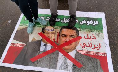 عراقيون يدوسون على صور لرئيس الوزراء العراقي السابق نوري المالكي ولأحد حلفائه السياسيين