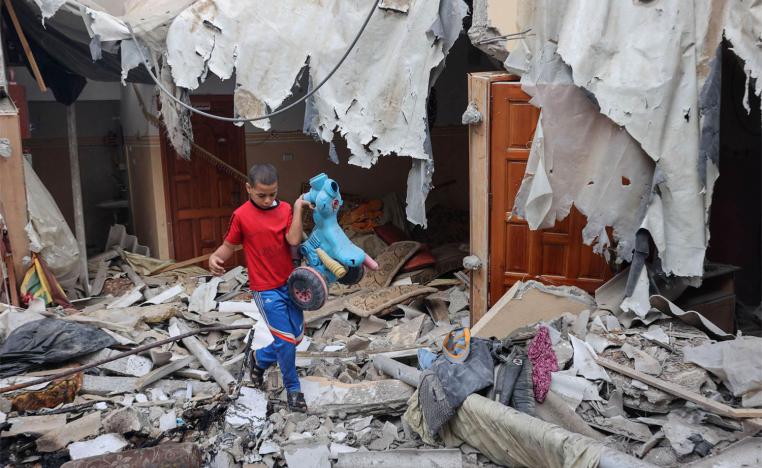 Palestinian boy salvaging a toy from the rubble of his house