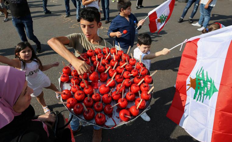 طفل يبيع تفاحا أثناء تظاهرة ي صيدا، جنوب لبنان