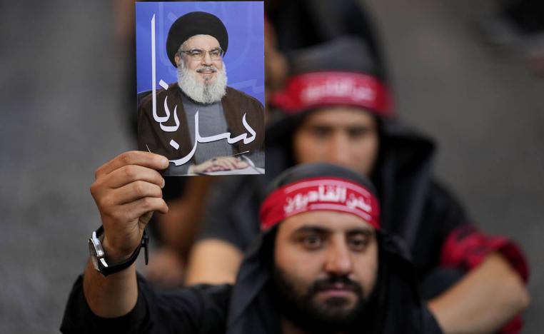 ناشط في حزب الله يرفع صورة لحسن نصرالله في احتفال بعاشوراء
