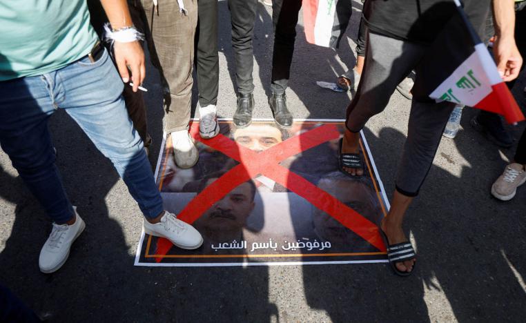محتجون عراقيون يدوسون على صور لرئيس البرلمان العراقي محمد الحلبوسي وعلى رئيس الوزراء المكلف محمد شياع السوداني