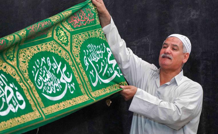 عراقي يرفع راية تحمل اسم الرسول محمد وعائلته علي وفاطمة