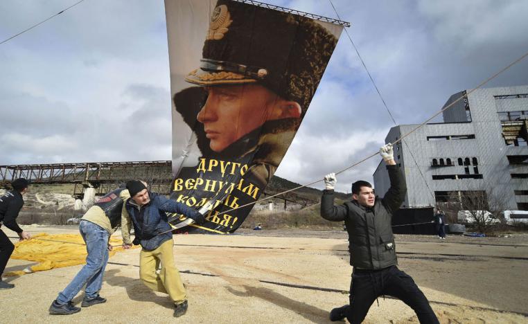 مؤيدون للرئيس الروسي فلاديمير بوتين يثبتون صورة له