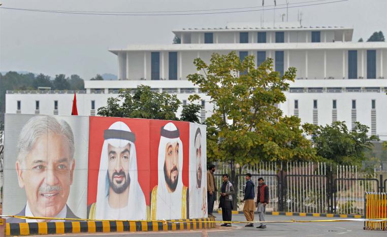 Workers arrange portraits of UAE President Sheikh Mohamed bin Zayed al-Nahyan (C) and Pakistan Prime Minister Nawaz Sharif (L) along the constitution avenue in Islamabad 
