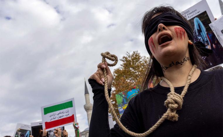 A member of the Iranian community living in Turkey holds a rope as letters on her neck reads, #no to death penalty during a protest
