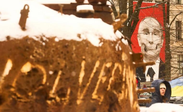 صورة مشوهة لبوتين بالقرب من دبابة روسية مدمرة على مقربة من كييف