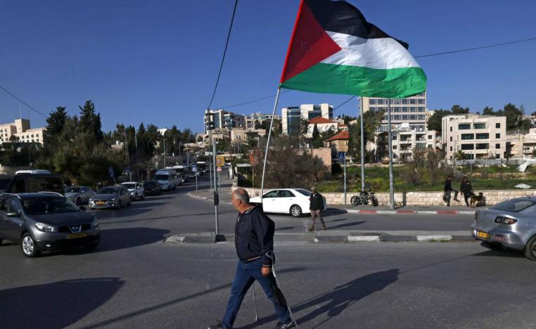 فلسطيني يحمل علما فلسطينيا في احتجاج في الشيخ جراح في القدس