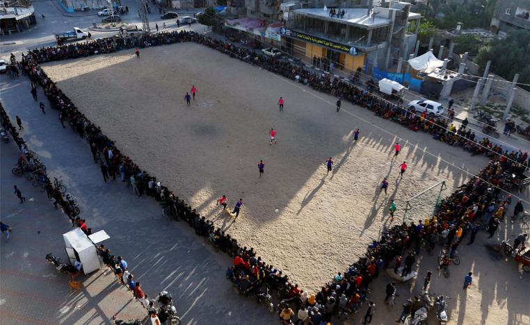 Young Palestinian men play football during tRamadan in Rafah 