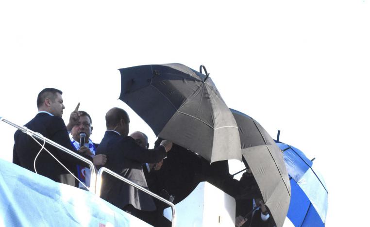 أكرم إمام أوغلو  يحتمي من الحجارة المساقطة قبل قطع خطابه