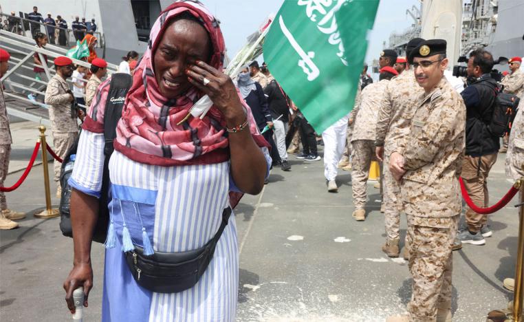 A Sudanese woman cries as she disembarks from Saudi Navy Ship with people from different nationality evacuated to Saudi Arabia from Sudan