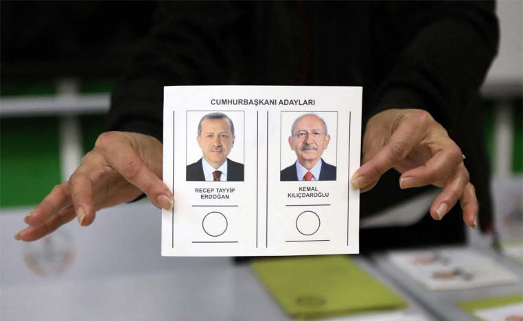 An election official displays a ballot