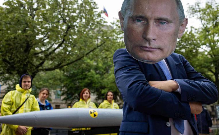 رجل يرتدي قناعا على صورة الرئيس الروسي بوتين